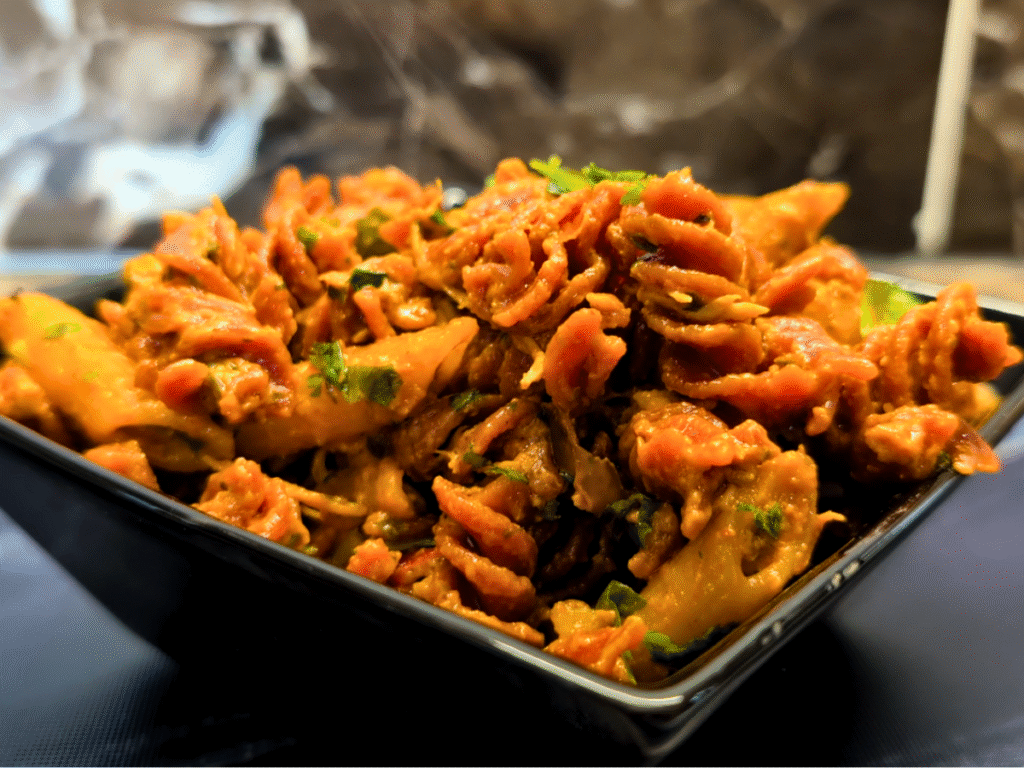 Cooked Roast Rebel Penne Pasta served in a black bowl.
